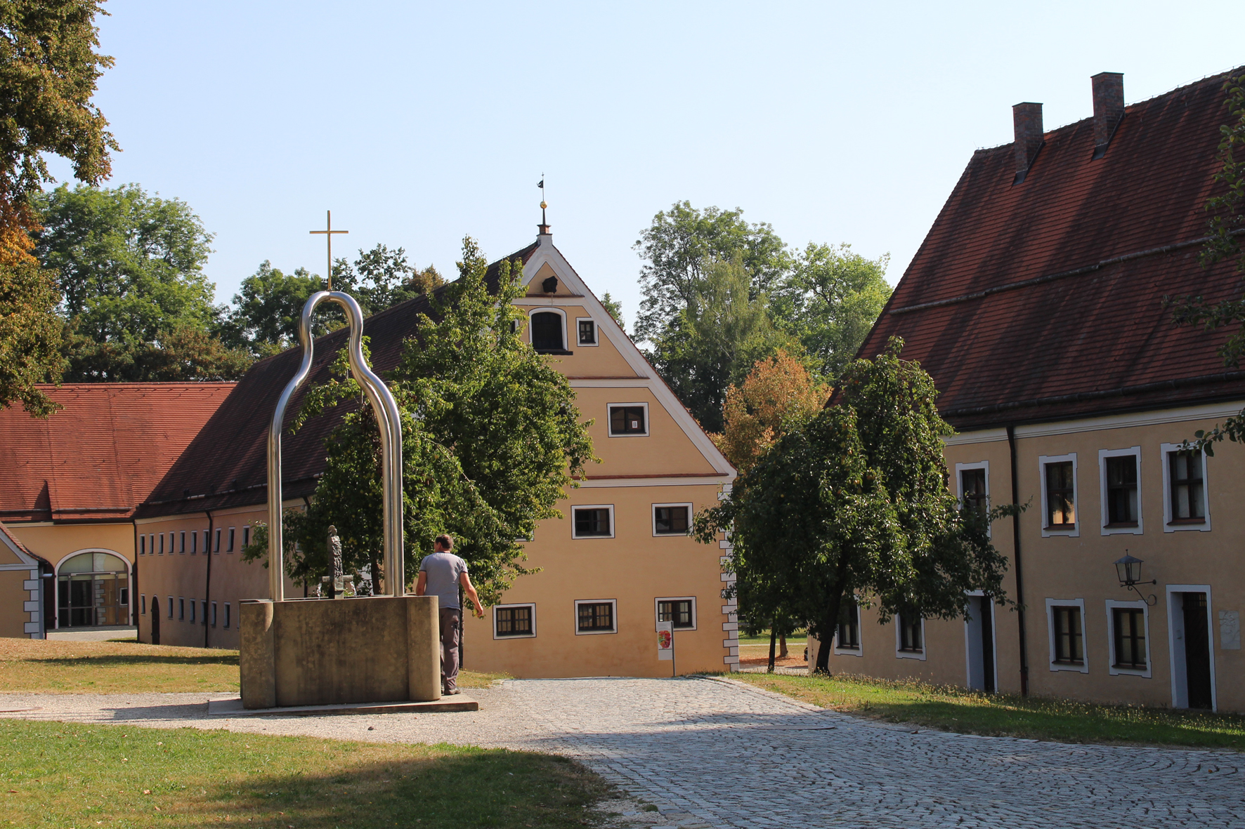 Brunnen und einige Gebäude mit Weg aus Kopfsteinpflaster