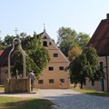 Brunnen und einige Gebäude mit Weg aus Kopfsteinpflaster