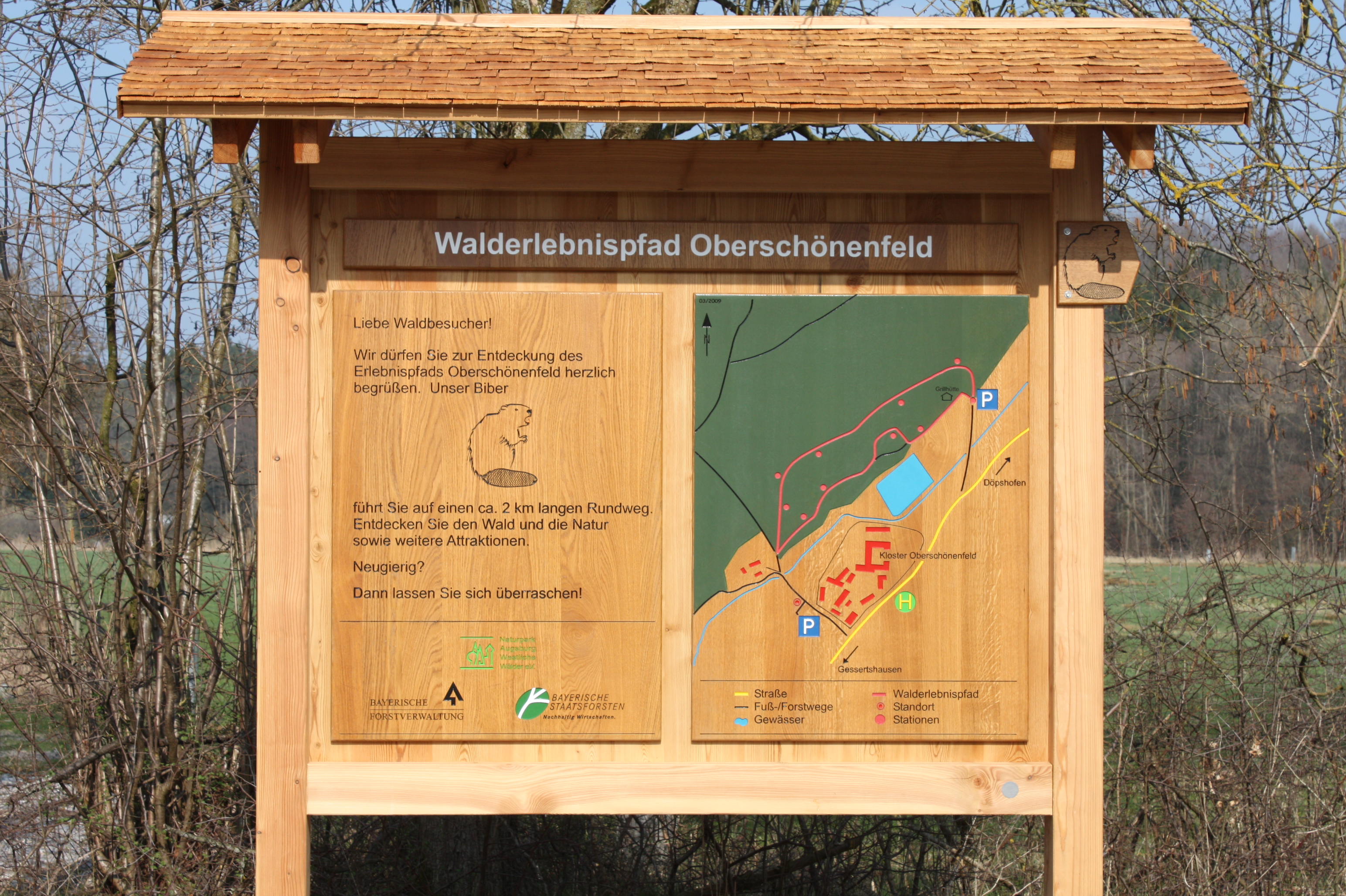 Infotafel aus Holz mit schmalem Holzdach