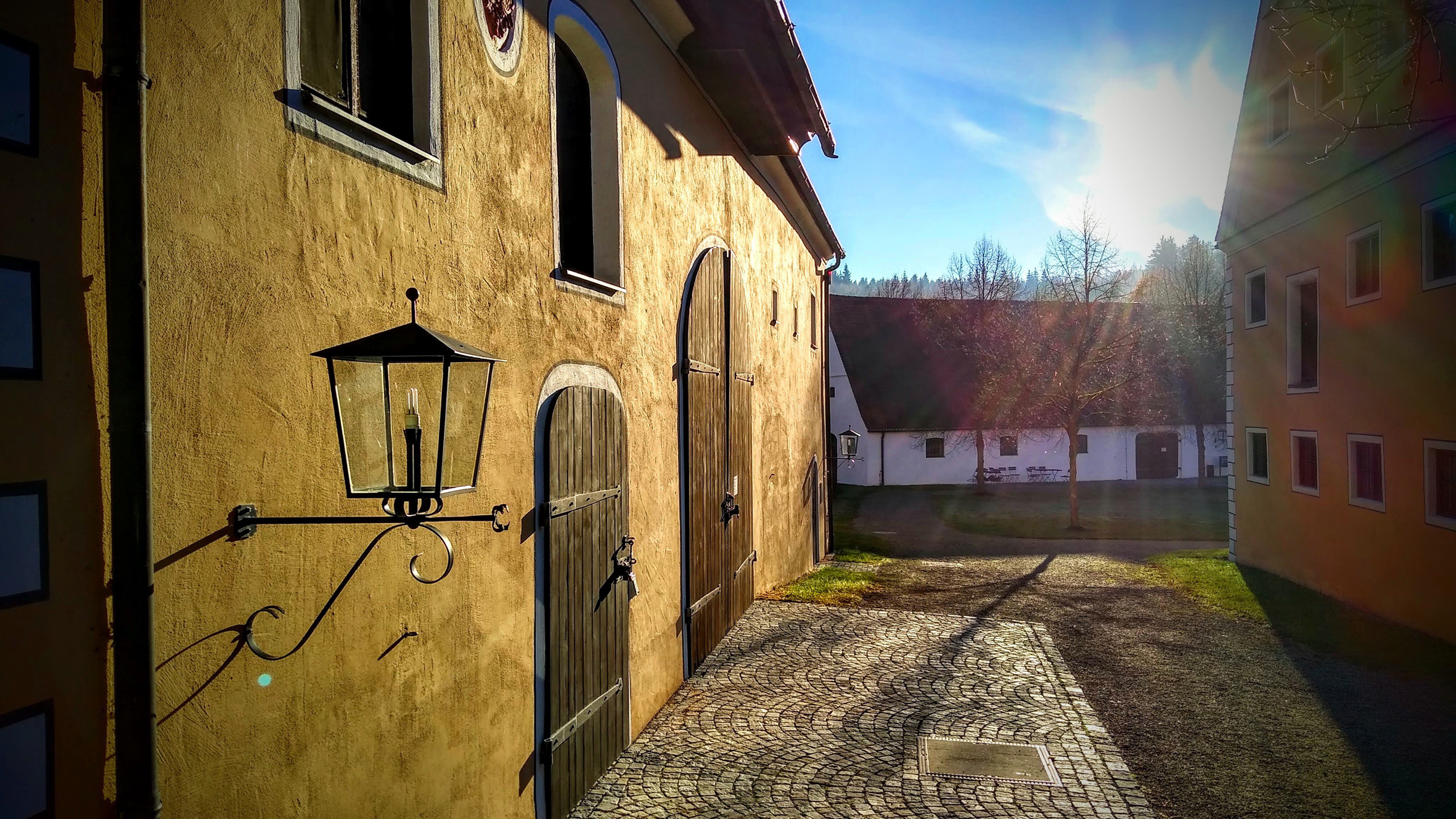 Fassade mit geschlossenen Holztoren von Abendsonne golden gefärbt