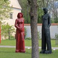 Zwei große Holzskulpturen neben einem Baum