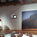Podeste mit Keramik neben großem Gemälde mit Wüstenlandschaft