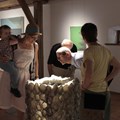 Mehrere Erwachsene und ein Kind stehen um Kunstobjekt