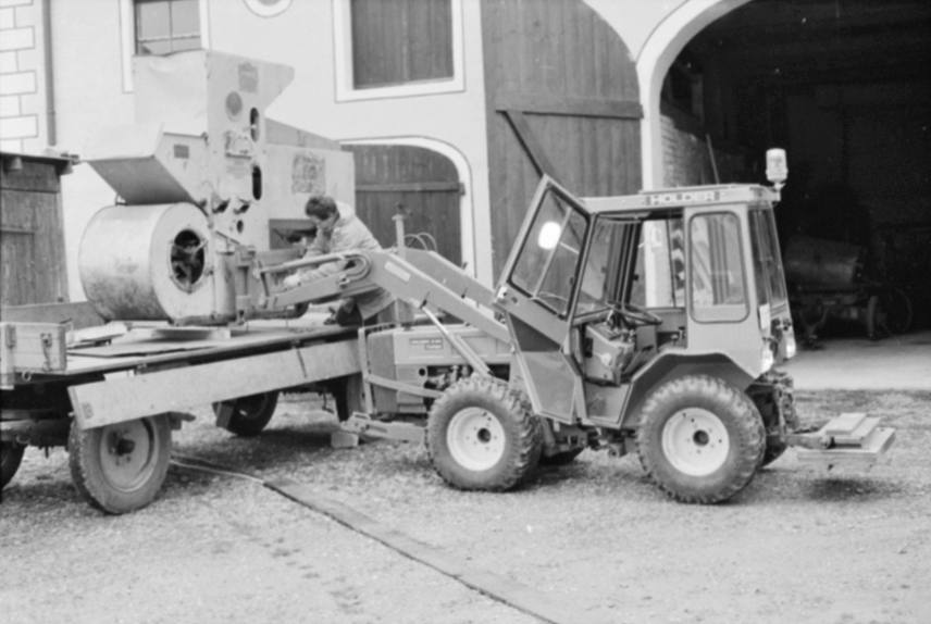 Gebäudeeingang und Anhänger, beladen mit Maschine als Sammlungsobjekt