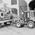 Gebäudeeingang und Anhänger, beladen mit Maschine als Sammlungsobjekt Gebäudeeingang und Anhänger, beladen mit Maschine als Sammlungsobjekt