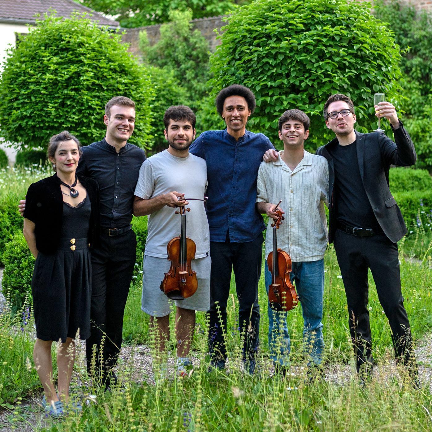 Fünf Musiker und eine Schauspielerin stehen nebeneinander im Grünen